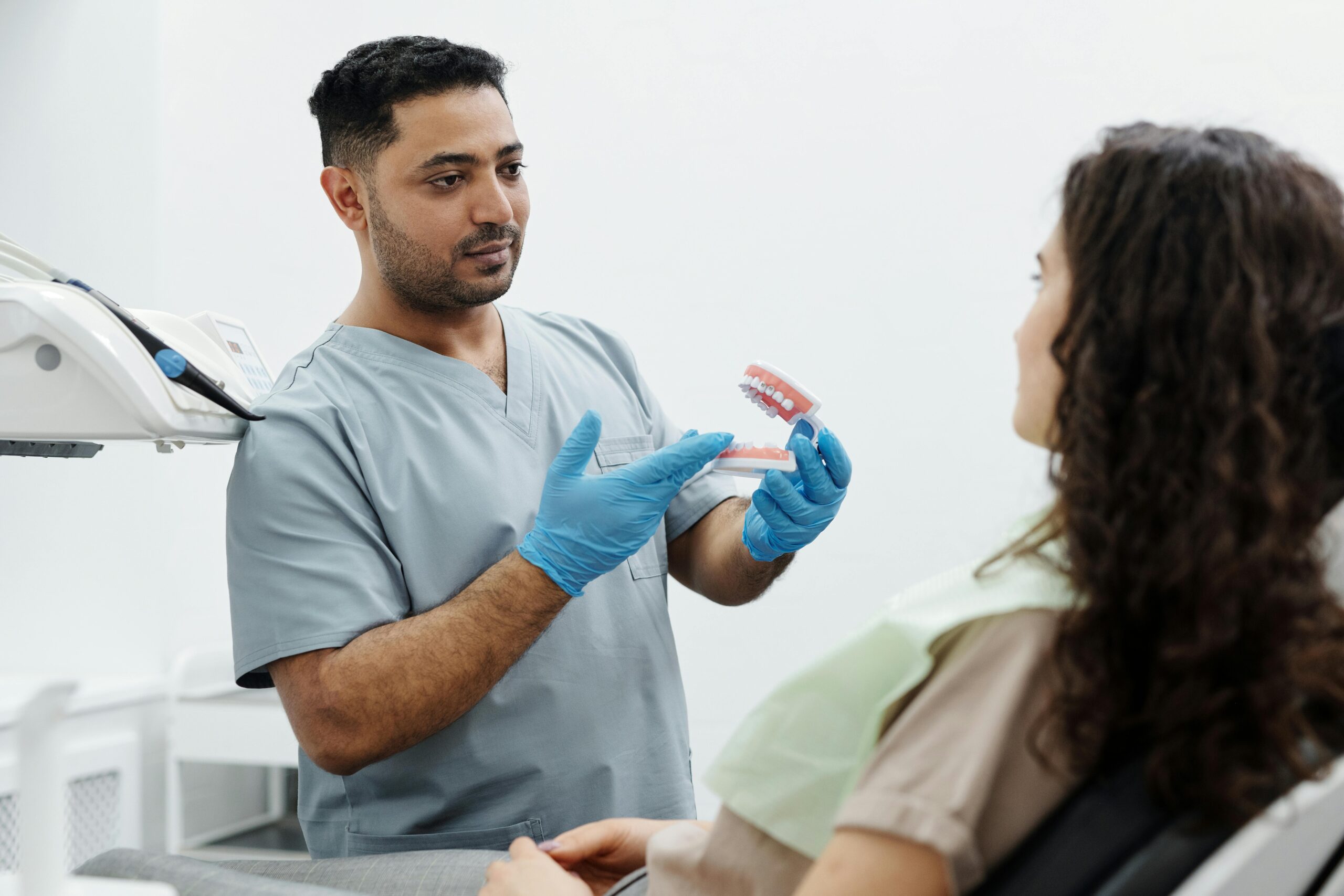Dental professional explaining All-on-4 dental implant options to a patient during a consultation