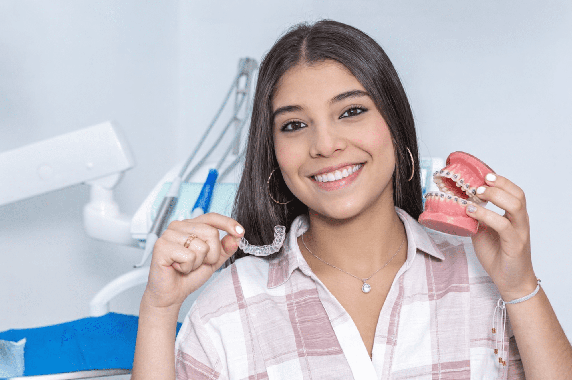 Adult patient comparing Invisalign clear aligners and braces at dental clinic